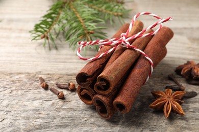 Different spices. Aromatic cinnamon sticks, anise stars and clove seeds on wooden table, closeup. Space for text