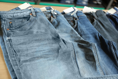 Photo of Modern blue jeans on display in shop, closeup