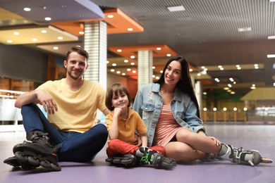 Happy family spending time at roller skating rink