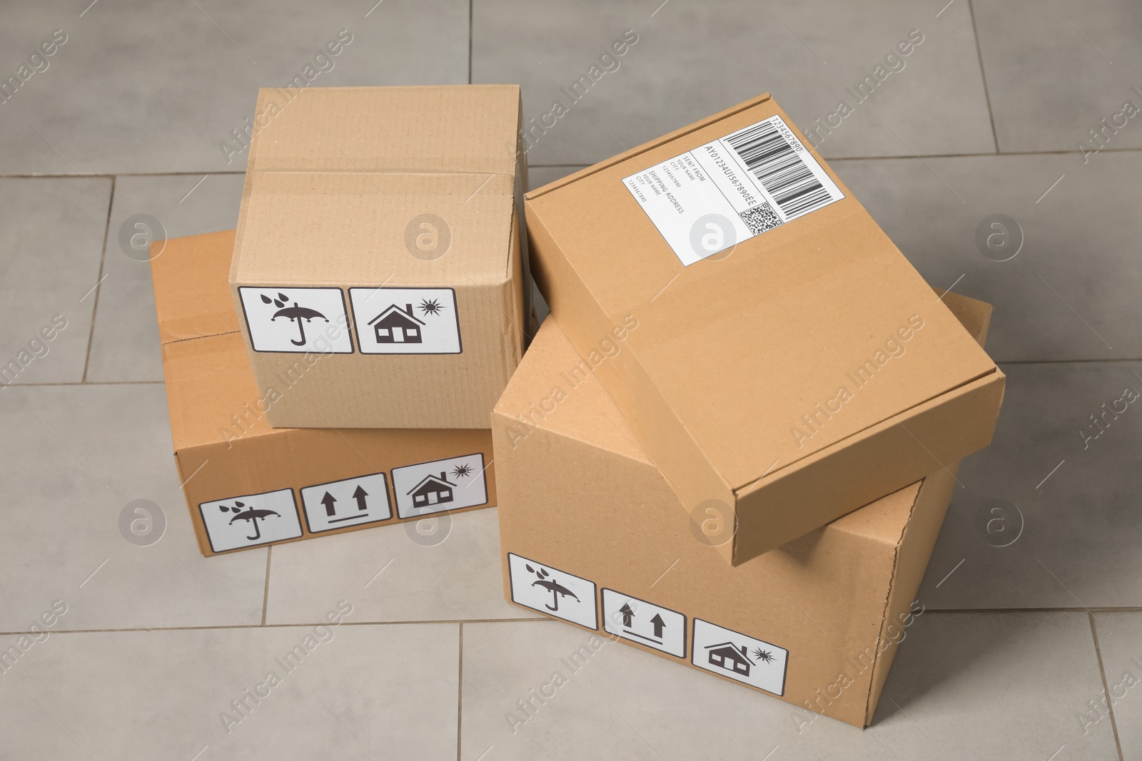 Photo of Many closed cardboard boxes with packaging symbols on floor. Delivery service