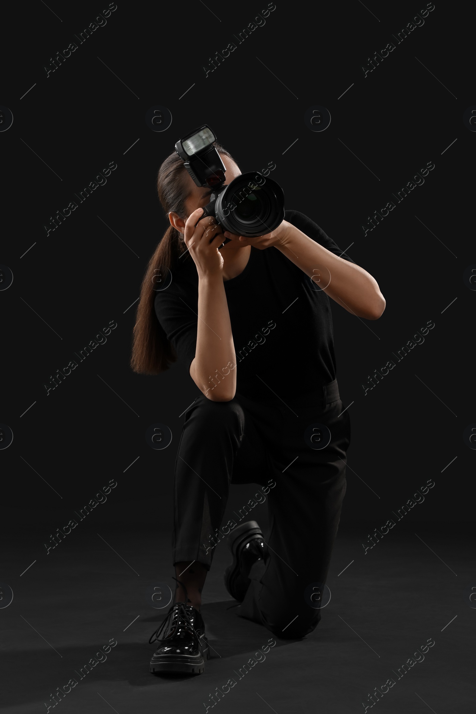 Photo of Professional photographer taking picture on black background