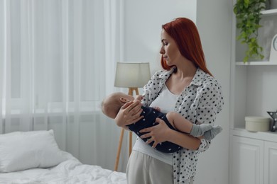 Photo of Mother with her cute baby in bedroom, space for text