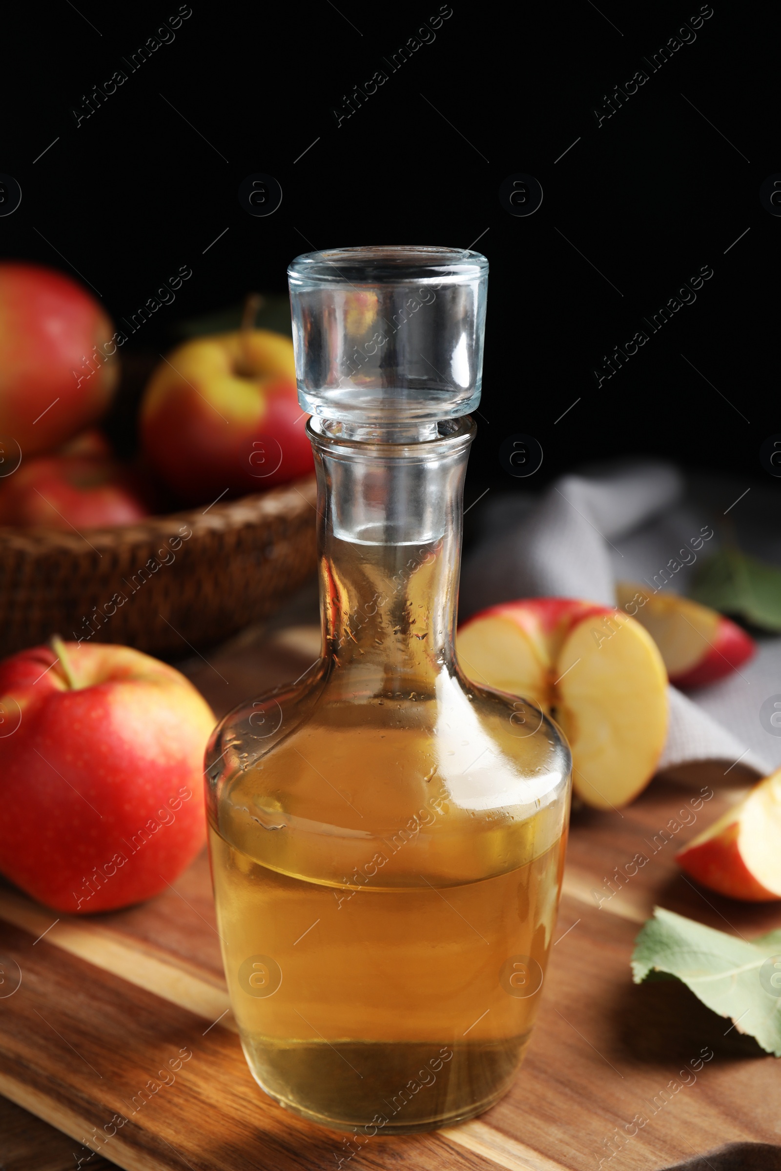 Photo of Natural apple vinegar and fresh fruits on wooden table