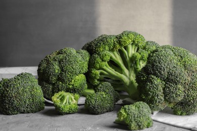 Photo of Fresh raw broccoli on grey textured table, closeup
