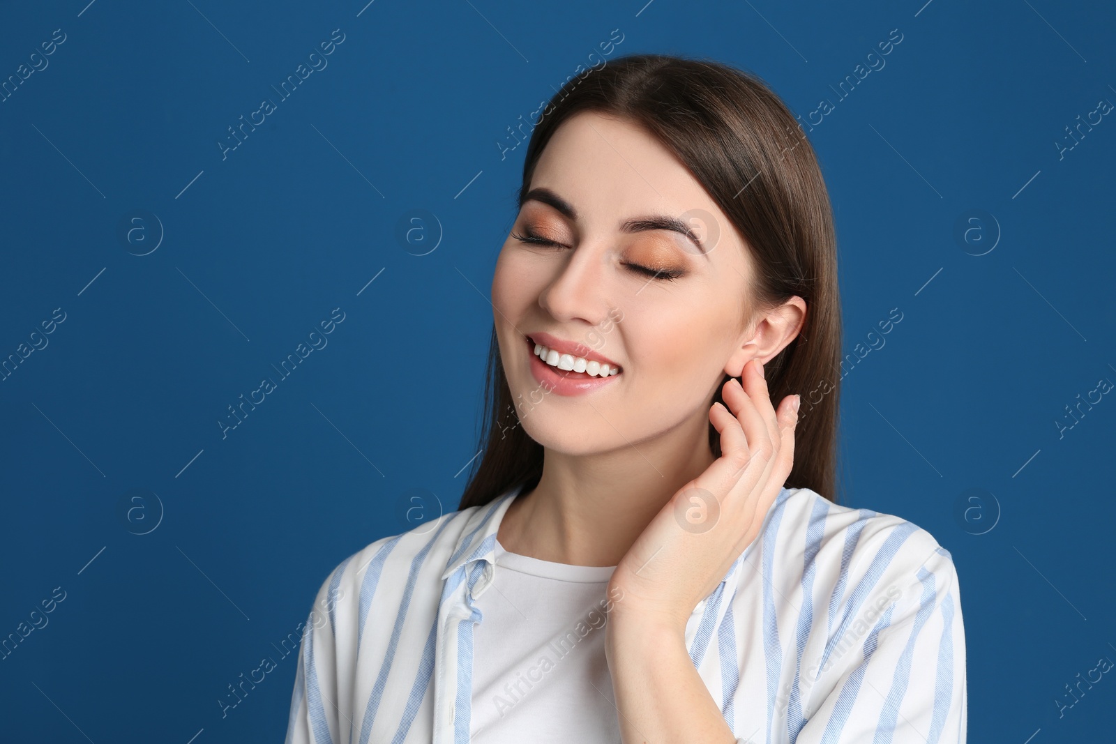 Photo of Portrait of happy young woman on blue background