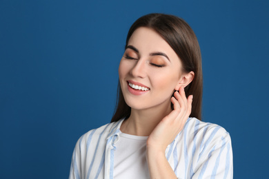 Portrait of happy young woman on blue background