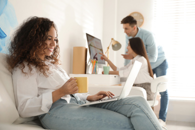 Professional designer working with laptop in modern office