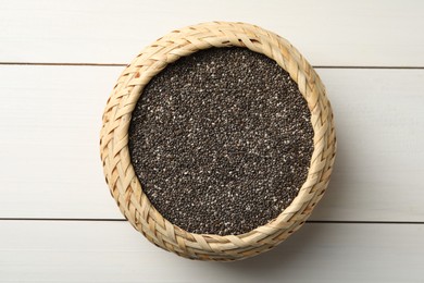 Photo of Wicker box with chia seeds on white wooden table, top view