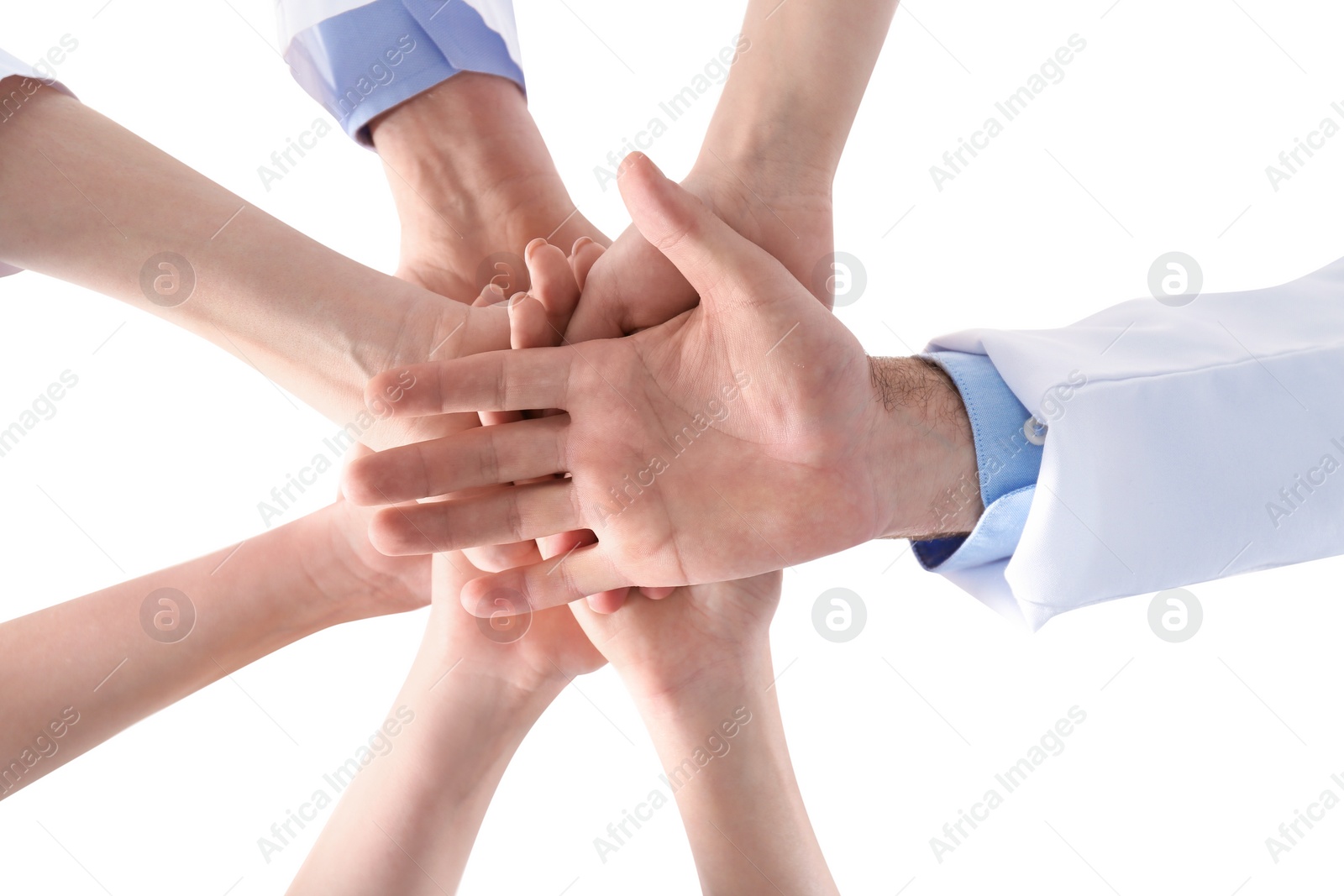 Photo of Team of medical doctors putting hands together on white background, closeup. Unity concept