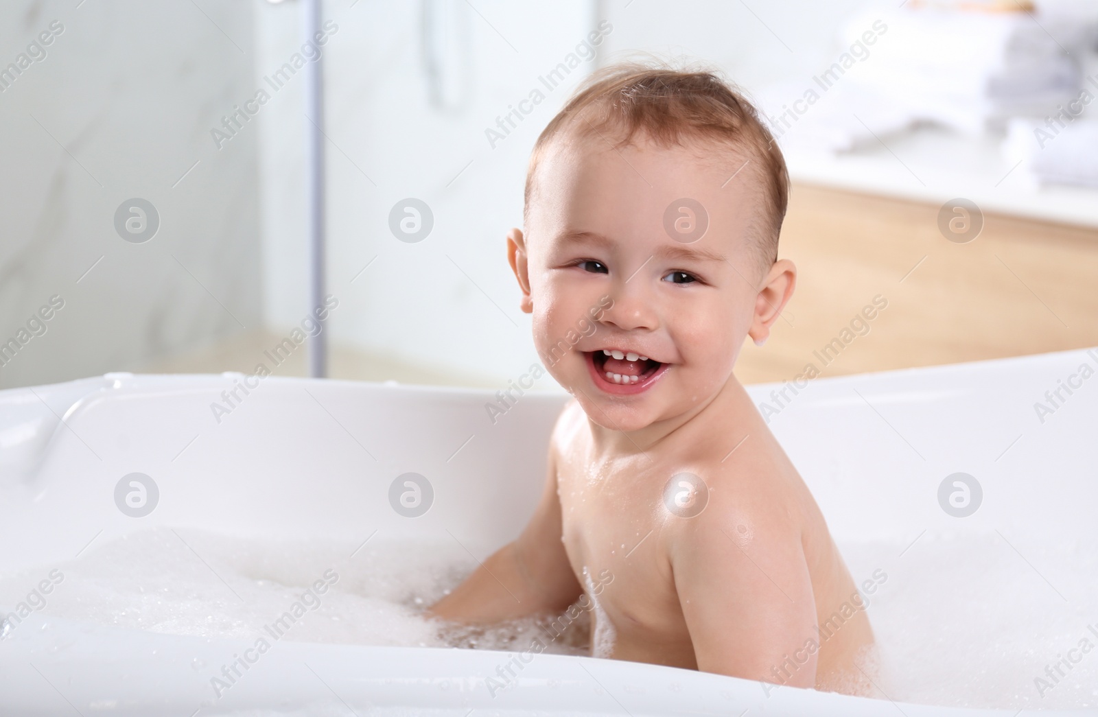 Photo of Cute little baby in bathtub at home