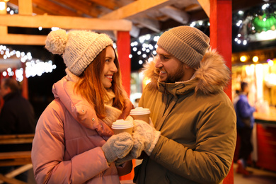 Photo of Happy couple with drinks at Christmas fair