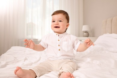 Photo of Happy baby boy on bed at home