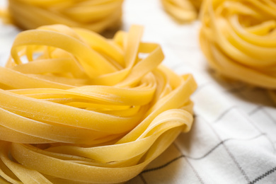 Photo of Tagliatelle pasta on white tablecloth, closeup view
