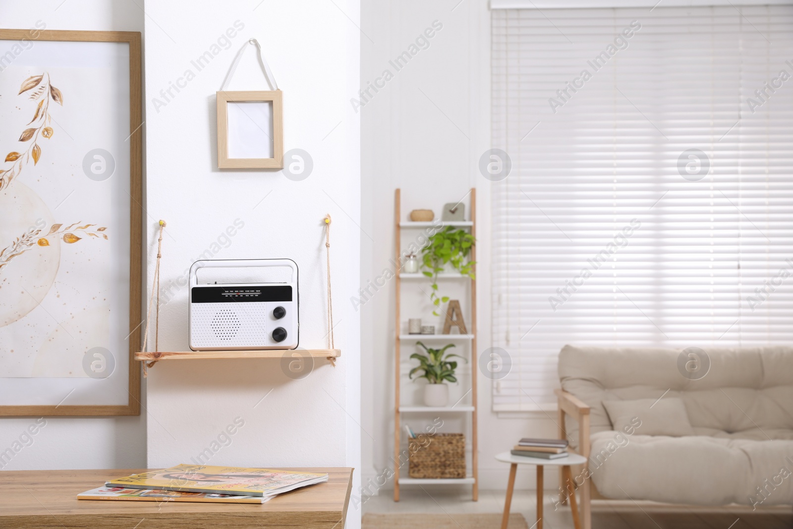 Photo of Stylish white radio on wooden shelf in living room interior