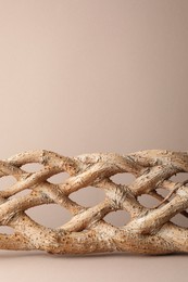 Presentation for product. Braided tree trunk on beige background. Space for text