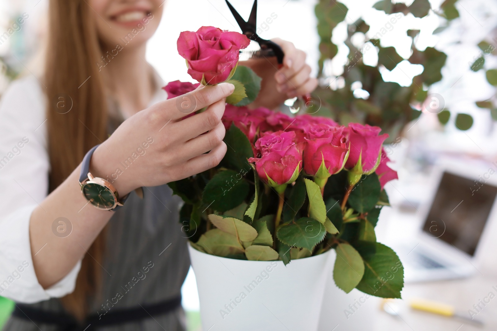 Photo of Female florist making beautiful bouquet in flower shop, closeup