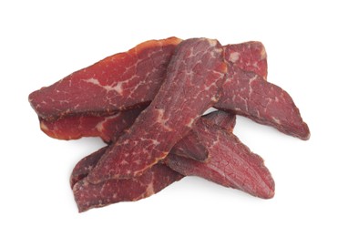 Photo of Pieces of delicious beef jerky on white background, above view