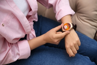 Woman using modern smart watch, closeup view