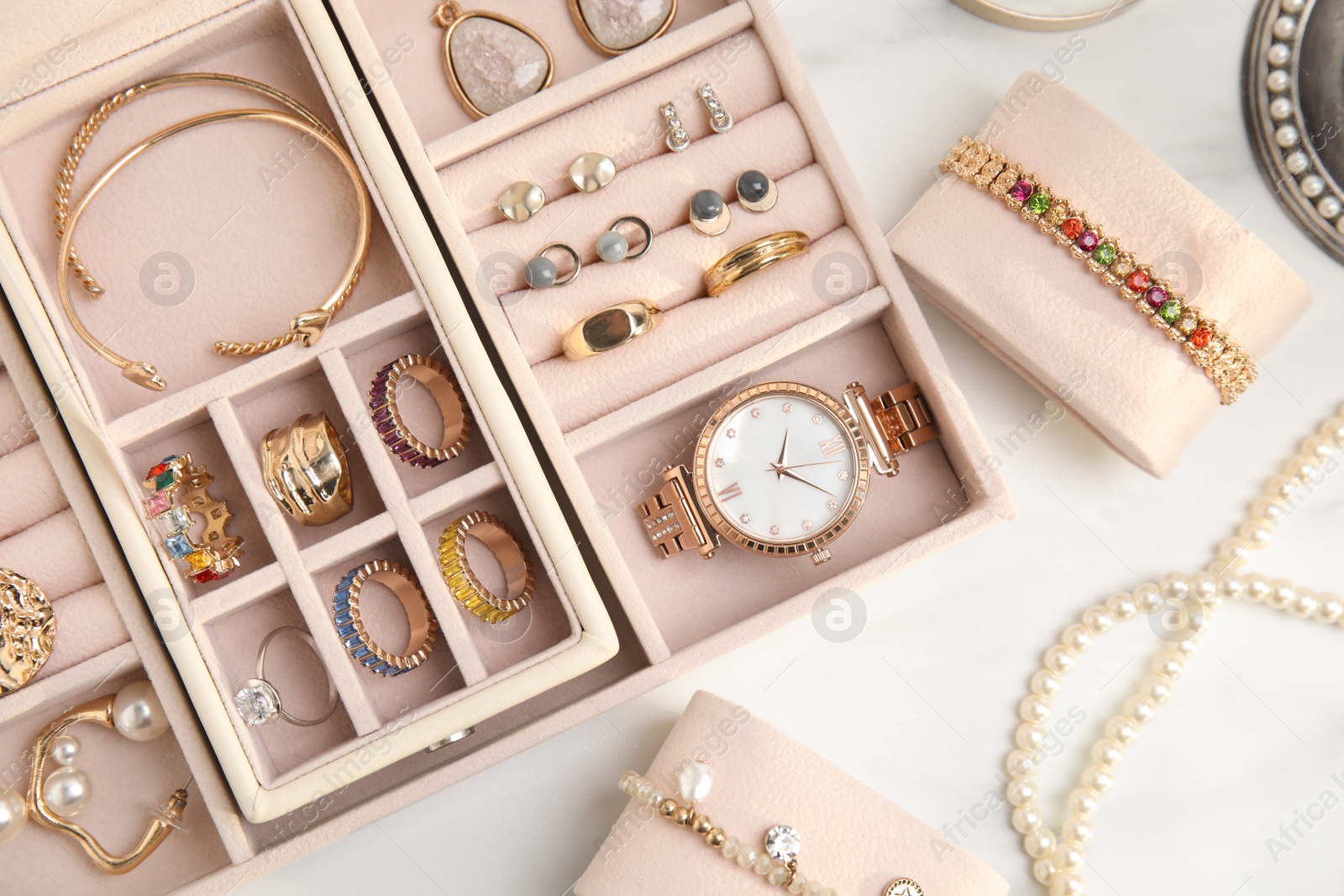 Photo of Jewelry box with stylish golden bijouterie on white table, flat lay