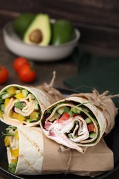 Photo of Delicious sandwich wraps with fresh vegetables on plate, closeup