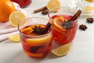 Photo of Aromatic punch drink and ingredients on white wooden table