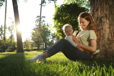Beautiful mother with her cute daughter spending time together in park on summer day