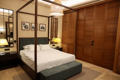 Photo of Large bed, lamps and pictures in comfortable hotel room