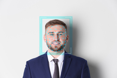 Image of Facial recognition system. Young man with scanner frame and digital biometric grid on white background