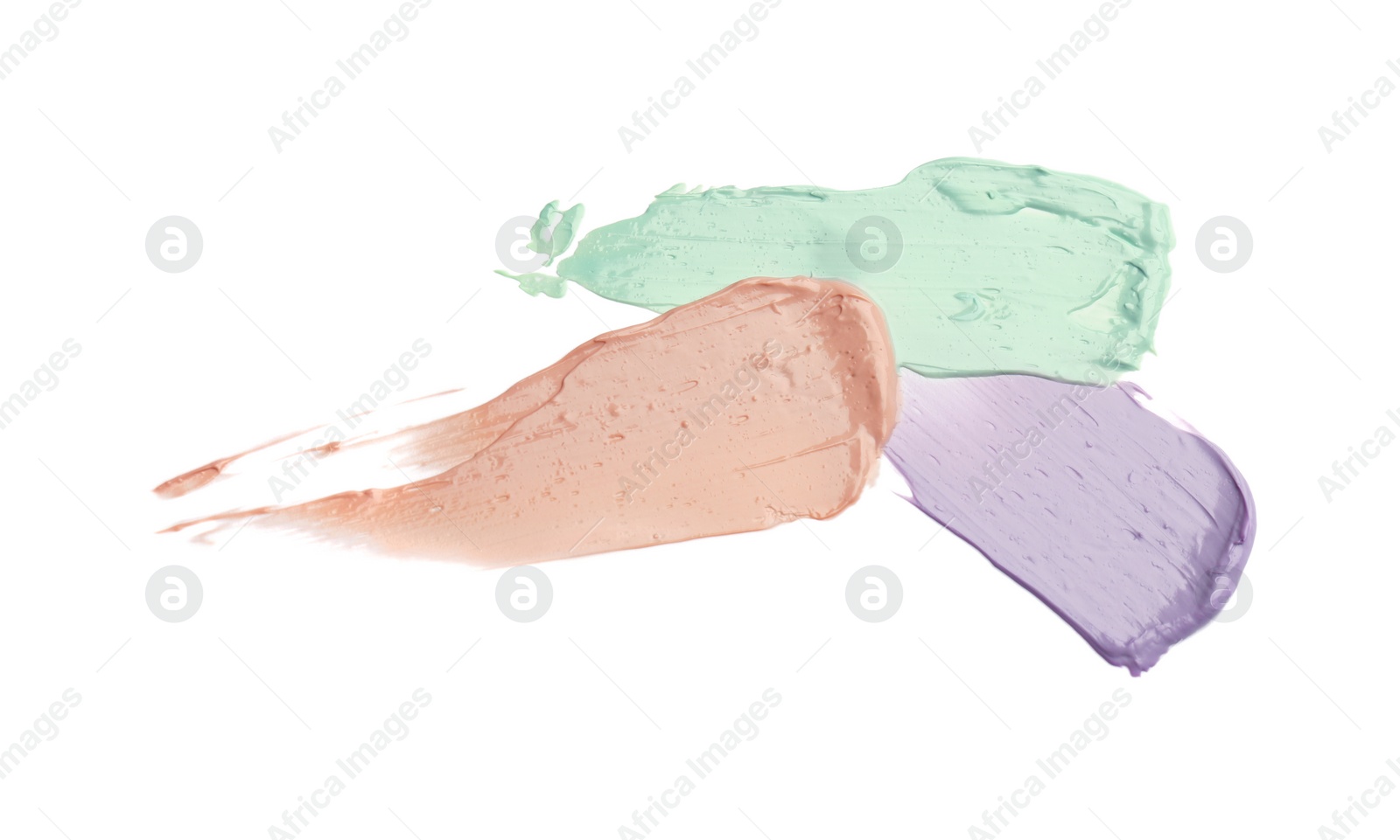 Photo of Strokes of pink, green and purple color correcting concealers isolated on white, top view