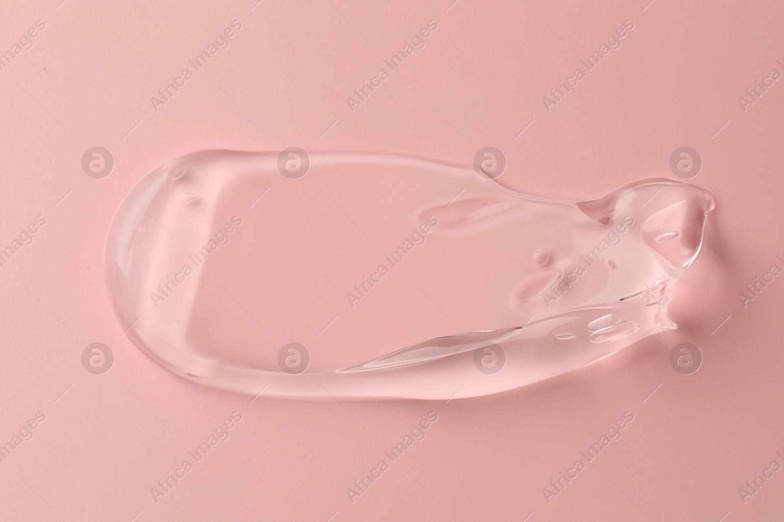 Photo of Sample of clear cosmetic gel on pink background, top view