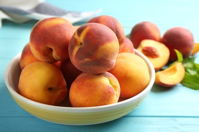 Photo of Fresh sweet peaches on turquoise wooden table, closeup