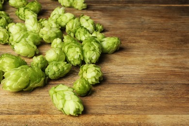 Fresh green hops on wooden table. Space for text