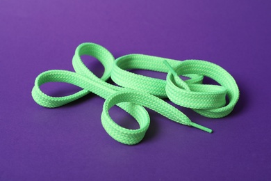 Photo of Mint shoe lace on purple background. Stylish accessory