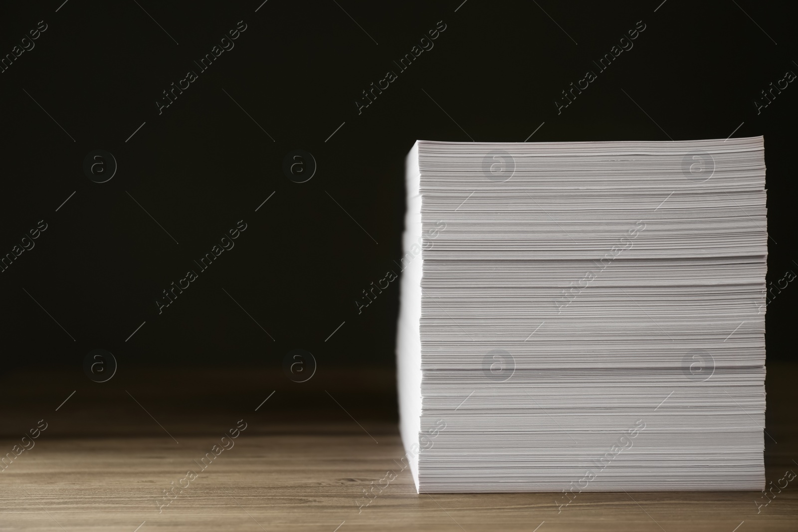 Photo of Stack of paper sheets on wooden table. Space for text