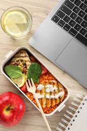 Photo of Healthy products high in vegetable fats near laptop on wooden table, flat lay