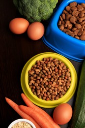 Dry pet food and products on wooden background, flat lay