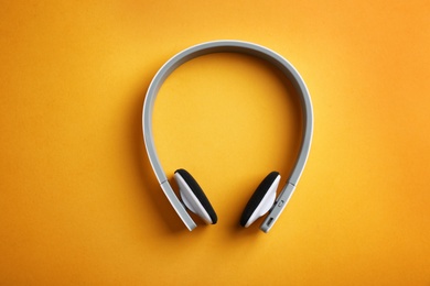 Photo of Wireless headphones on color background, top view