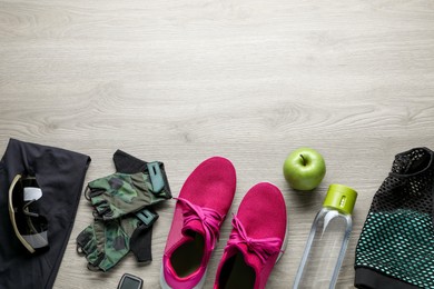 Flat lay composition with different cycling accessories on wooden background, space for text