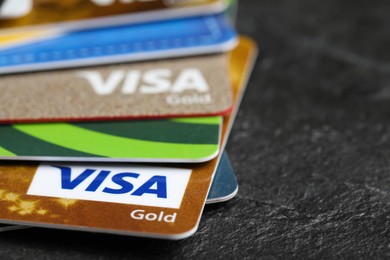 Photo of MYKOLAIV, UKRAINE - FEBRUARY 22, 2022: Visa credit cards on black background, closeup. Space for text