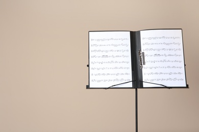 Note stand with music sheets on color background. Space for text