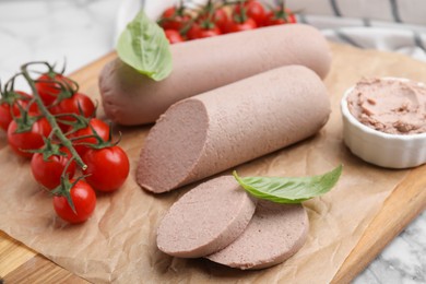Photo of Delicious liver sausages, paste and cherry tomatoes on table, closeup