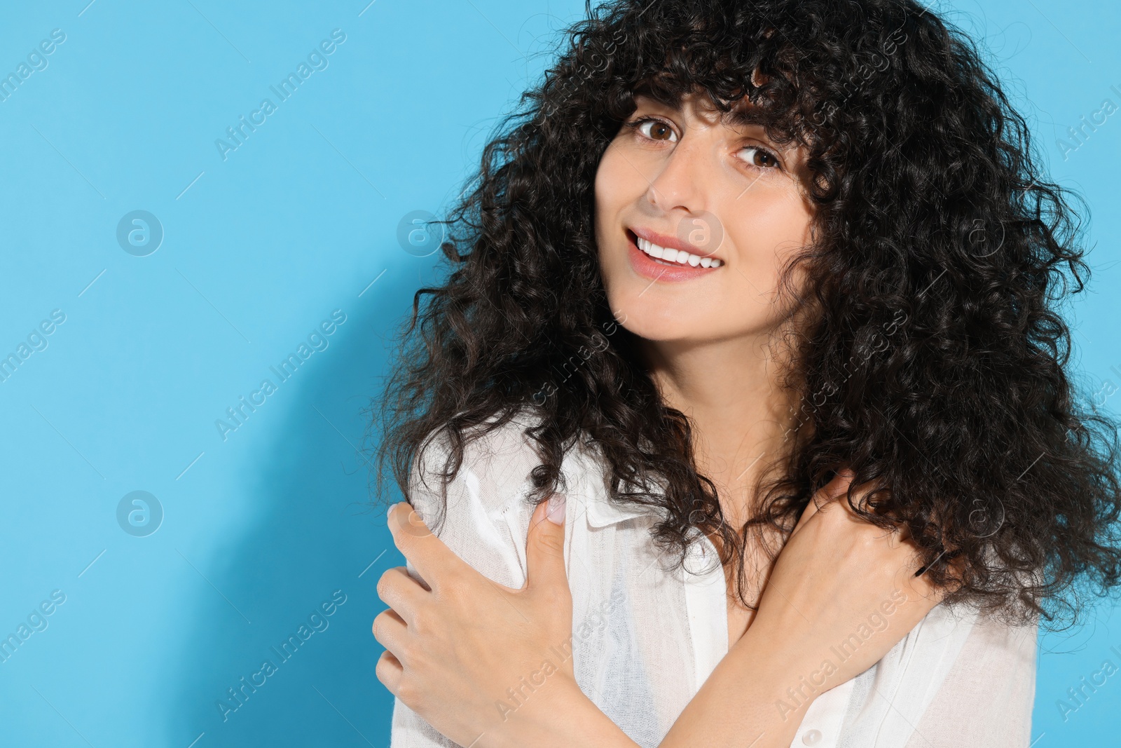 Photo of Portrait of beautiful young woman on light blue background, space for text