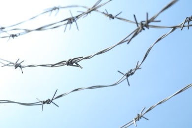 Metal barbed wire on light blue background