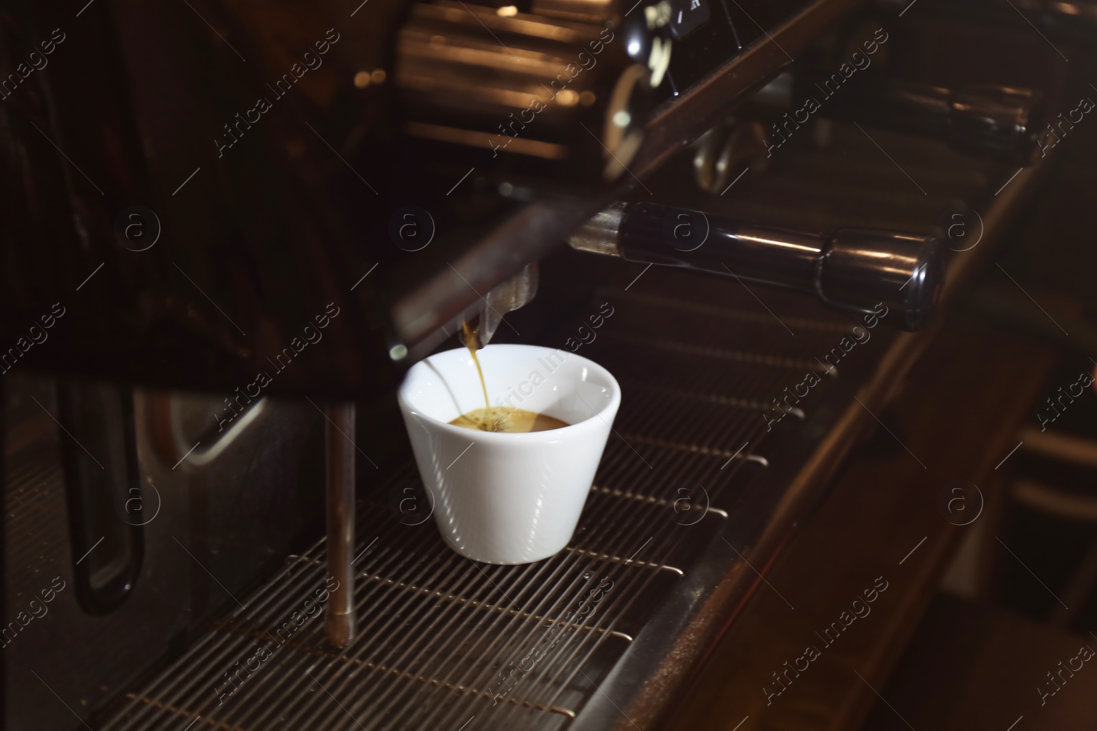 Photo of Preparing fresh aromatic coffee on modern machine, closeup