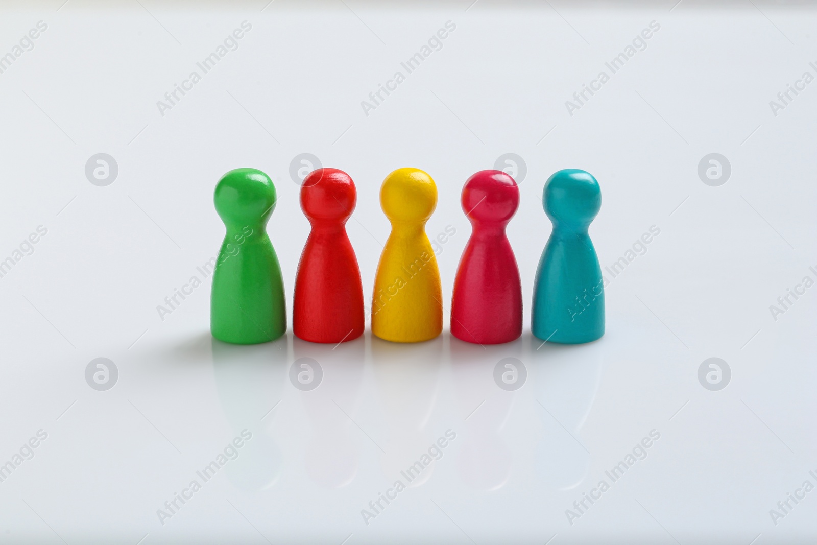 Photo of Colorful pawns on white background. Social inclusion concept