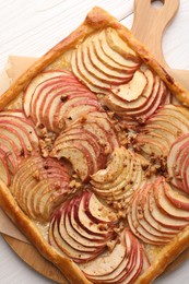 Tasty fresh apple galette on white wooden table, top view