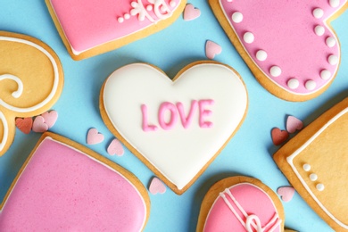 Photo of Composition with decorated heart shaped cookies on color background, top view. Valentine's day treat