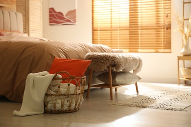 Photo of Bedroom interior with bed, basket and bench