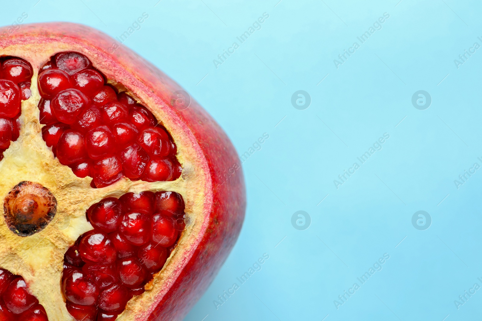 Photo of Ripe red pomegranate fruit with juicy seeds on color background, top view. Space for text