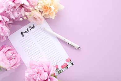 Guest list, pen and beautiful flowers on violet background, flat lay. Space for text